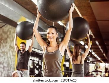 Healthy Young People Working Out With Pilates Ball At A Gym.