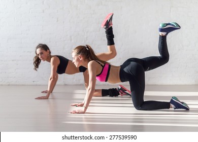 Healthy Young Sportswoman Doing The Exercises On All Fours Arching Back Straightening Leg Up Concept Sport, Fitness, Lifestyle.