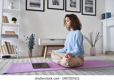 Healthy Young Woman Meditating At Home Watching Online Tv Yoga Class E Tutorial On Laptop Computer Doing Virtual Pilates Exercises, Breathing, Relaxing Body And Mind, Mental Health Care Concept.