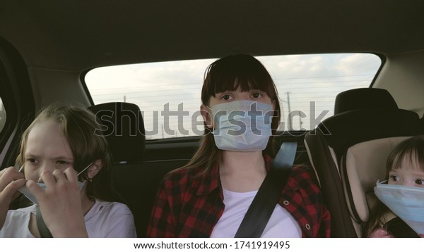 Healthy young woman in protective sterile medical\
mask drives a car. concept of pandemic coronavirus. free girl\
travels in a mask in a car. protection against viruses and\
bacteria. girl rides a\
car