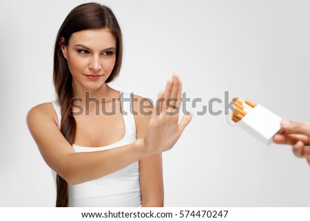 Healthy Young Woman Refusing To Take Cigarette From Pack. Portrait Of Beautiful Female Showing Stop Sign With Hand To Cigarettes. Quit Smoking Concept. High Resolution