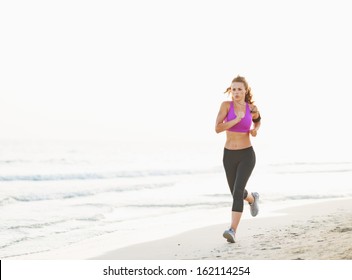 Healthy Young Woman Running On Beach