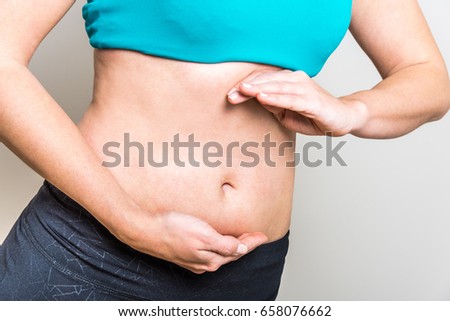 Healthy young woman's belly with hands build a circle