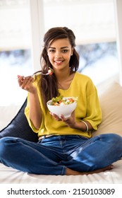 Healthy And Yum. Portrait Of A Young Woman Eating A Salad At Home.