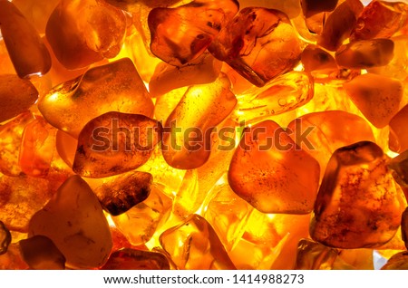 a heap of amber stones backlightet glowing