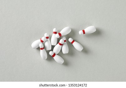 Heap Of Bowling Pins On Grey Paper Background, Top View