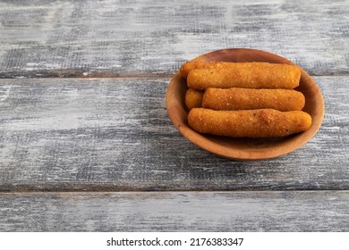 Heap Of Cheese Sticks On A Wooden Plate On A Gray Wooden Background. Side View, Flat Lay, Close Up, Copy Space.