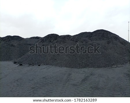 A heap of coal in a yard with ground also black due to the dust Stock photo © 