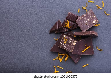 Heap Of Dark Chocolate Slices With Orange Zest, Top View