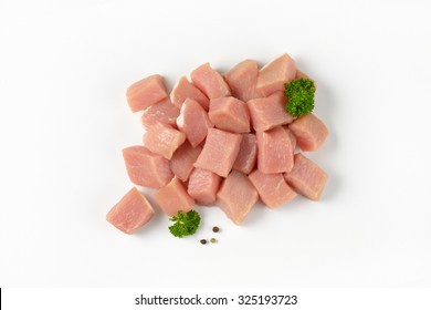 heap of diced raw pork tenderloin on white background