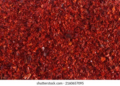 Heap of dried red chili flakes as background. Spices and herbs. Top view. Free space for text.
