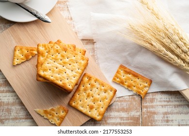 Heap of Dry thin crispy crackers on cutting board on wood table.Top view with copy space