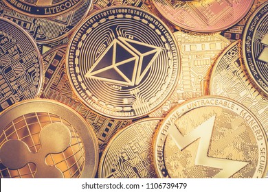 A heap of Ethereum (ETH) physical golden and shiny coins along with different other cryptocurrencies (monero, ripple) with a vintage look. Ethereum is a digital blockchain cryptocurrency
