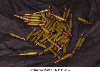 Heap Of The Former Soviet 5.45×39mm Service Rifle Cartridges On A Black Textile Surface
