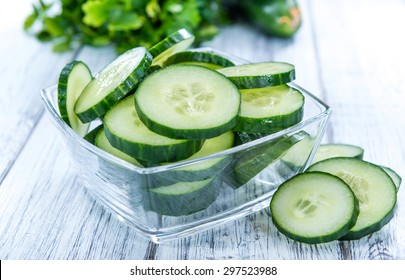 Heap of fresh sliced Cucumbers on an old wooden table - Shutterstock ID 297523988
