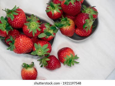 Heap Of Fresh Strawberries In Ceramic Bowl On White Table Cloth Background.