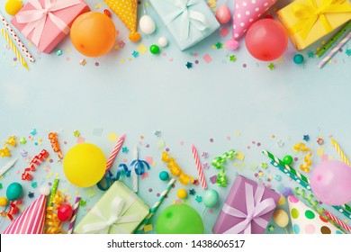 Heap Of Gift Or Present Boxes, Balloons, Holiday Supplies And Confetti On Blue Table Top View. Birthday Party Background.