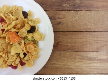 Heap of golden Cornflakes on a rustic wooden table