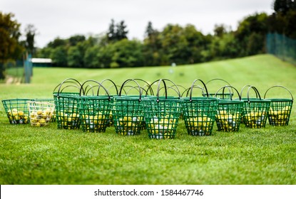 Heap Of Golf Balls In Basket Ready For Warm Up. Bunch Of Golf Balls In Green Basket Ready On Green Morning Lawn On Golf Course Intended For Players Warming Up With Long Drive Swing.