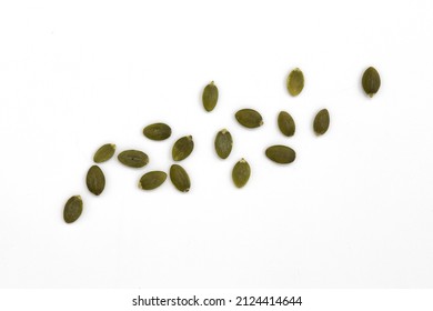 montón de semillas de calabaza verde aisladas en fondo blanco, semillas de peletería crudas dispersas, vista superior