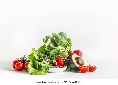 Heap Of Healthy Salad Ingredients At White Background: Lettuce, Tomato, Avocado, Pomegranate Seeds And Raspberry. Front View.