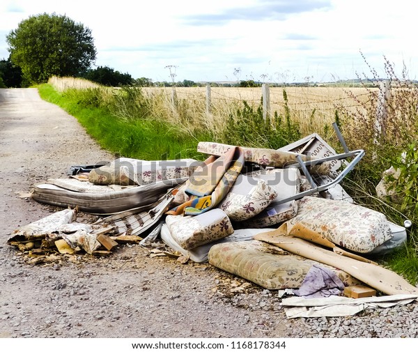 Heap of illegally\
dumped household rubbish left in a little used country lane.\
Environmental hazard, with furniture. mattresses and carpets. Fly\
tipped detritus.\
Oxfordshire.