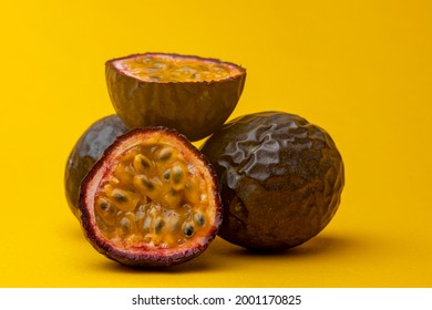Heap of Maracuja or Brazilian tropical passion fruit studio food still life against a yellow background