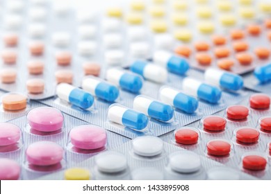Heap of medical pills in white, blue and other colors. Pills in plastic package. Concept of healthcare and medicine. - Shutterstock ID 1433895908