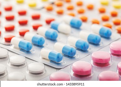 Heap of medical pills in white, blue and other colors. Pills in plastic package. Concept of healthcare and medicine. - Shutterstock ID 1433895911