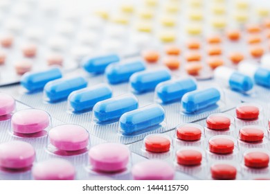 Heap of medical pills in white, blue and other colors. Pills in plastic package. Concept of healthcare and medicine. - Shutterstock ID 1444115750