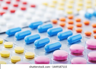 Heap of medical pills in white, blue and other colors. Pills in plastic package. Concept of healthcare and medicine. - Shutterstock ID 1449187115
