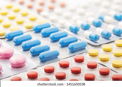Heap of medical pills in white, blue and other colors. Pills in plastic package. Concept of healthcare and medicine. - Shutterstock ID 1451650538