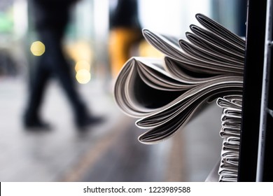 A heap of newspapers on a news stand on the background of a street - Shutterstock ID 1223989588