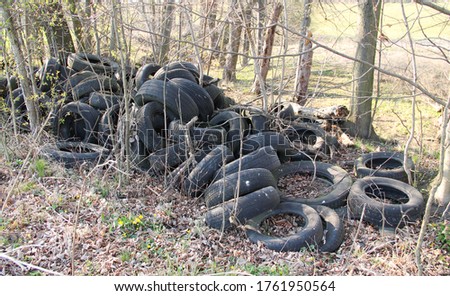heap of old car tyres in the nature, ecological problem