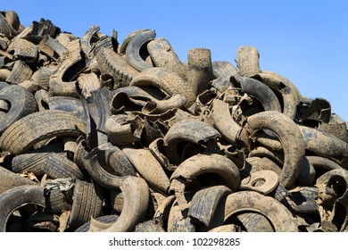 Heap of old muddy chopped up tires are piled in a recycling yard waiting to be remanufactured in to new products. - Powered by Shutterstock