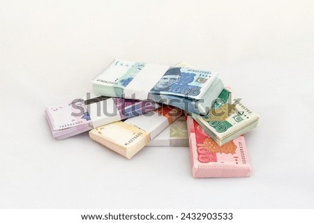 Heap of Pakistani currency bundles on white isolated background