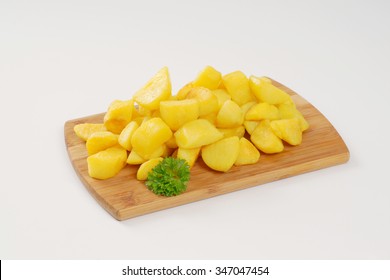 heap of pan fried potatoes on wooden cutting board