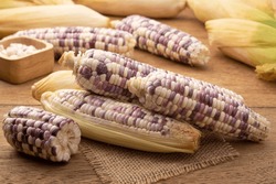 Heap Of Peeled Waxy Sweet Purple Corn On Wooden Table