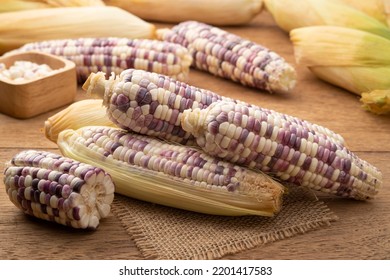 Heap of peeled waxy Sweet purple corn on wooden table - Shutterstock ID 2201417583