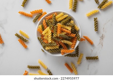 Heap of raw tricolor Fusilli gluten free pasta isolated on white background