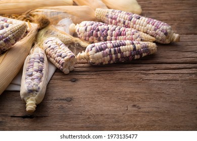 Heap of raw Waxy corn on wooden table with copy space. - Shutterstock ID 1973135477