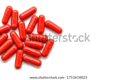 Heap of red pills isolated on white background. Macro. Close up view. Tablets scattered on a table. Pharmacy. Treatment. Copy space for your text