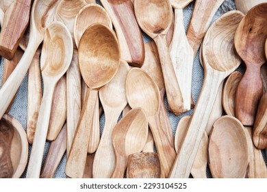 Heap of rustic wooden spoons handmade from different types of wood, lying on table as background. Flat lay. Top view. Handmade concept - Powered by Shutterstock