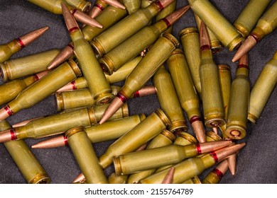 Heap Of The Service Rifle Cartridges On A Black Textile Surface, Fragment Close-up
