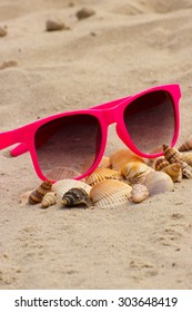 Heap Of Shells And Pink Sunglasses Lying On Sand At The Beach, Vacation And Summer Time, Eye Protection