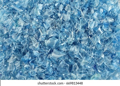 A heap of small pieces of chopped blue plastic bottles. Top-down view. Closeup