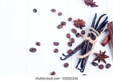 Heap Of Spices Cinnamon Sticks, Vanilla Sticks, Coffee Bean And Anise Stars Isolated On White Wooden Background