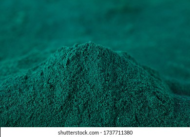 Heap of spirulina algae powder on a blurred background. Superfood concept. Macro photography.