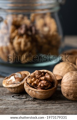 Heap of splited walnuts on rustic wooden table. vertical