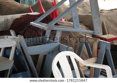 a heap of trestles or saddles, fishingnets and chairs near the coast of El Morche